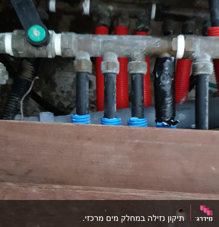 צינורות מים עם מחברים וברזים מתחת לכיור